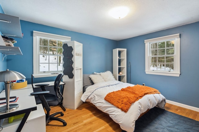 bedroom featuring light wood-style flooring and baseboards