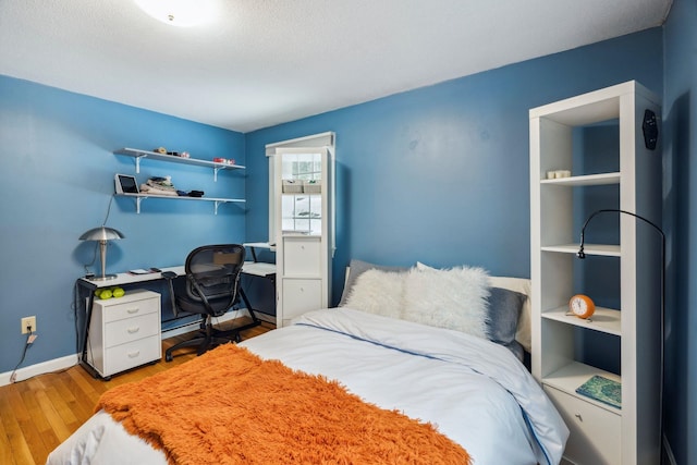 bedroom featuring baseboards and wood finished floors