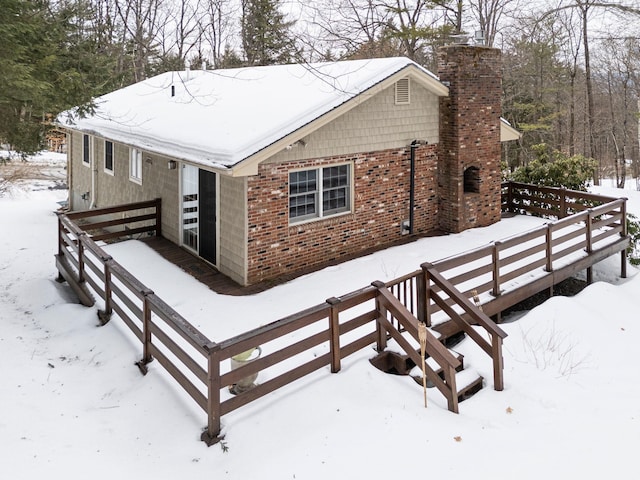 view of front facade featuring brick siding and a chimney