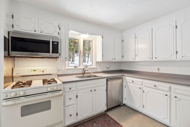 kitchen featuring light countertops, appliances with stainless steel finishes, a sink, and white cabinets