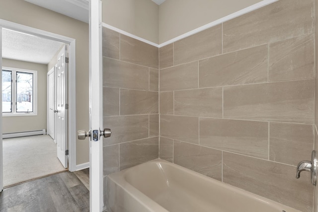 full bath with washtub / shower combination, a baseboard radiator, and wood finished floors