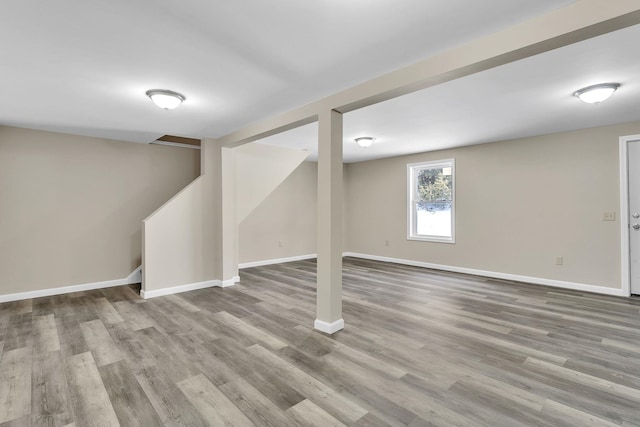 basement with baseboards and wood finished floors