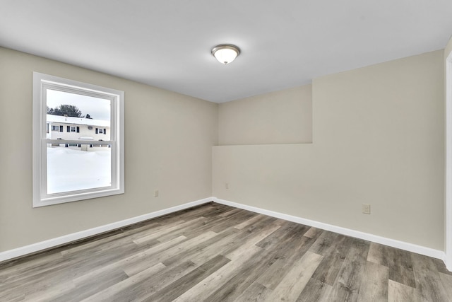 spare room with wood finished floors and baseboards