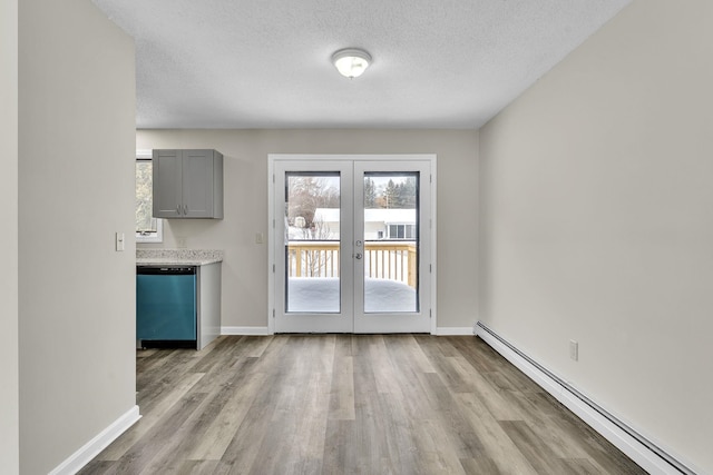 doorway with a baseboard heating unit, french doors, a textured ceiling, and wood finished floors