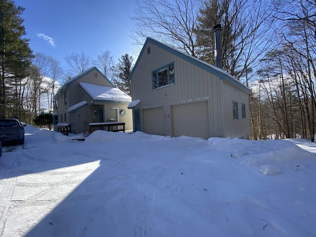 view of snowy exterior featuring a garage