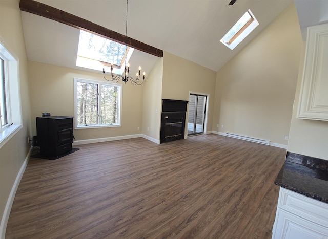 unfurnished living room with a skylight, dark wood-style floors, high vaulted ceiling, a fireplace, and a baseboard heating unit