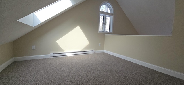 additional living space with carpet floors, lofted ceiling with skylight, baseboards, and a baseboard heating unit