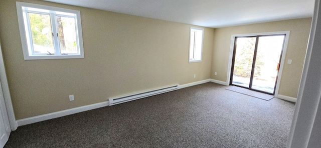 empty room with a baseboard heating unit, a healthy amount of sunlight, carpet floors, and baseboards