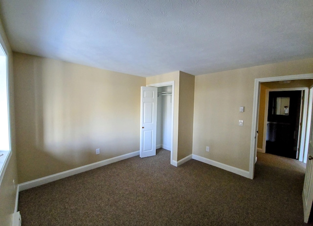 unfurnished bedroom featuring carpet floors, a closet, and baseboards