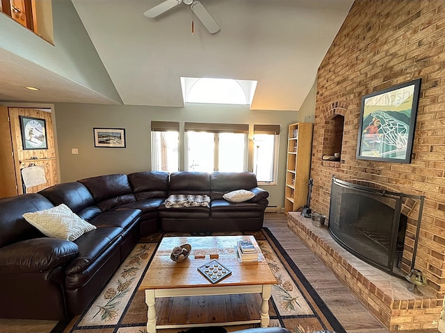 living area featuring a fireplace, high vaulted ceiling, a ceiling fan, and wood finished floors