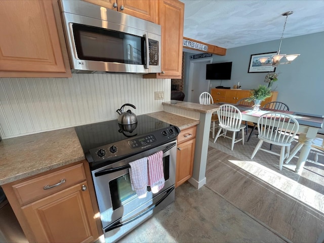 kitchen featuring stainless steel appliances, light wood-type flooring, light countertops, and pendant lighting