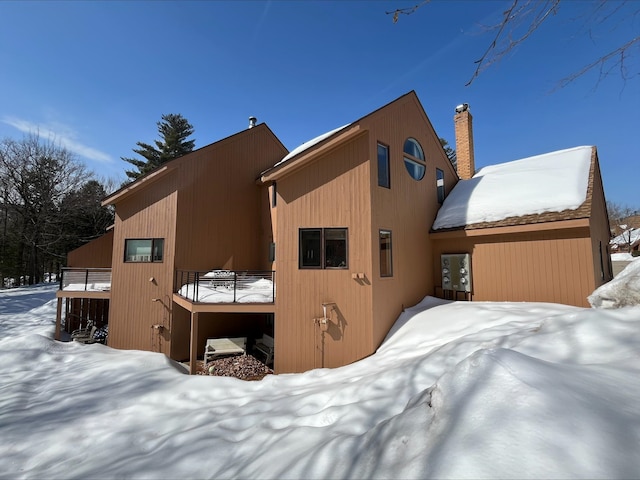 view of snow covered back of property