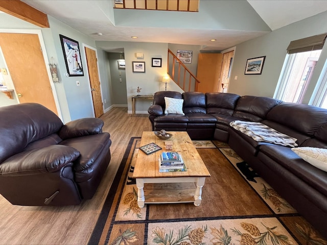 living room featuring baseboards, lofted ceiling, wood finished floors, stairs, and recessed lighting