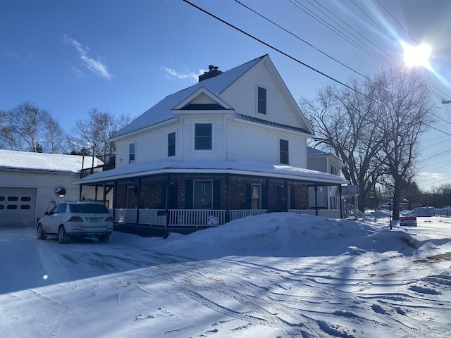 view of front of house with a garage, a porch, and a chimney