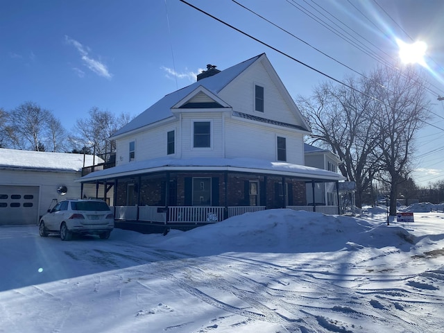 view of front of house featuring covered porch, a chimney, and a garage