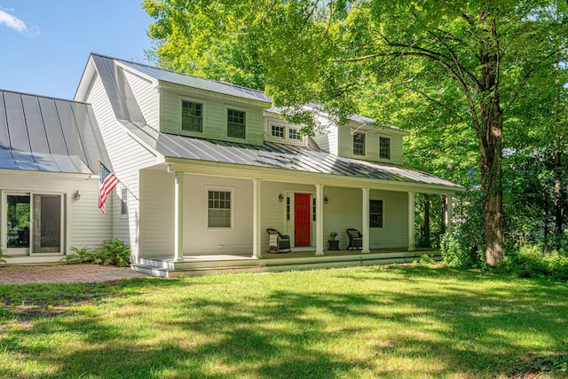 view of front of house featuring metal roof, a porch, a standing seam roof, and a front yard