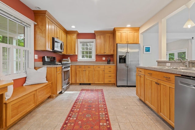 kitchen with decorative light fixtures, recessed lighting, appliances with stainless steel finishes, light tile patterned flooring, and a sink