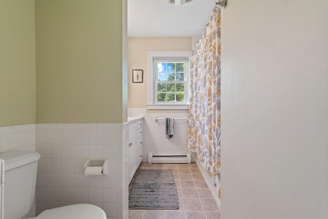 full bath featuring tile walls, a baseboard radiator, toilet, wainscoting, and tile patterned floors