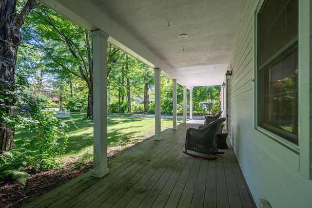 wooden deck with a porch and a lawn