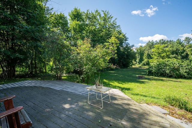 wooden deck featuring a lawn