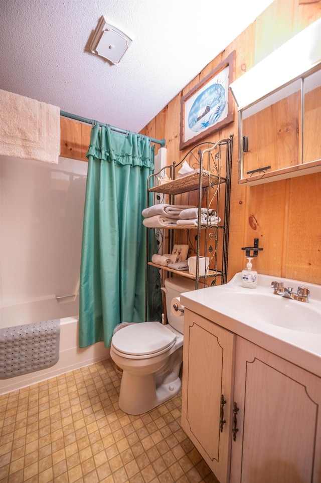 full bathroom with wooden walls, toilet, vanity, a textured ceiling, and shower / bath combination with curtain