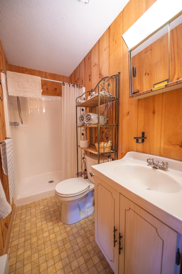 full bathroom featuring toilet, wooden walls, a textured ceiling, vanity, and a shower with curtain