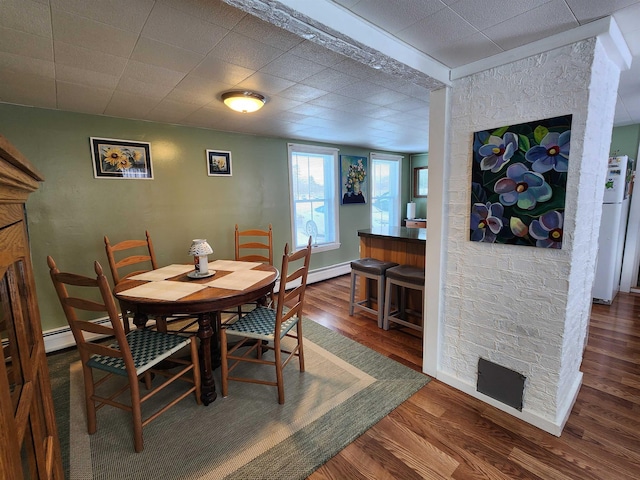 dining area featuring dark wood-type flooring and baseboards