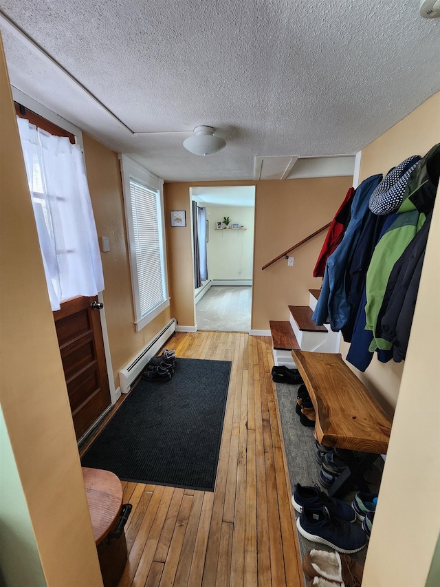 mudroom with a baseboard radiator, baseboards, wood-type flooring, and a textured ceiling