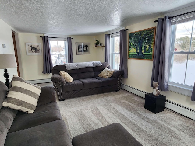 carpeted living room featuring a healthy amount of sunlight, baseboard heating, and a textured ceiling