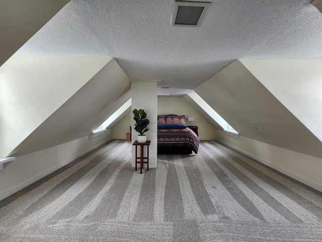 unfurnished bedroom with carpet, baseboards, vaulted ceiling, and a textured ceiling