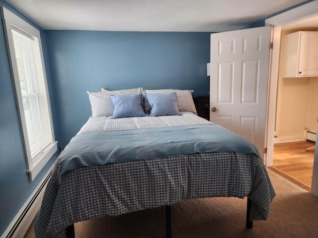 bedroom with a baseboard radiator and a textured ceiling