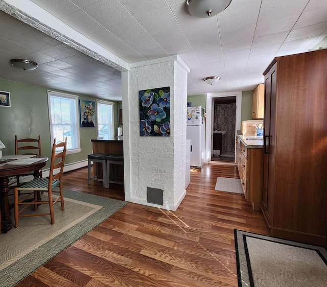 interior space with dark wood-type flooring, baseboards, and baseboard heating