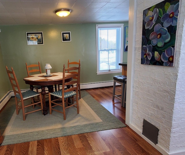 dining room with a baseboard radiator, baseboards, and wood finished floors