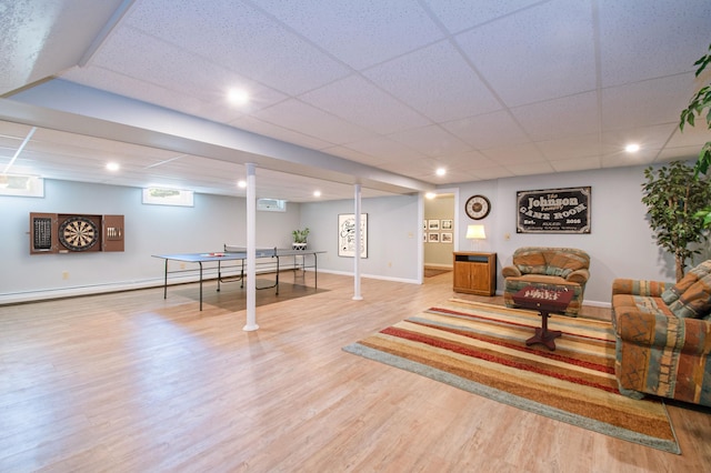 living area featuring baseboards, wood finished floors, a paneled ceiling, a baseboard heating unit, and recessed lighting