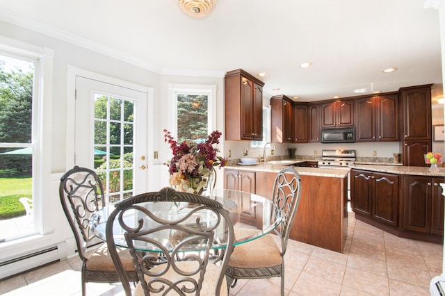 kitchen with light tile patterned floors, a baseboard radiator, a sink, black microwave, and stainless steel gas range oven