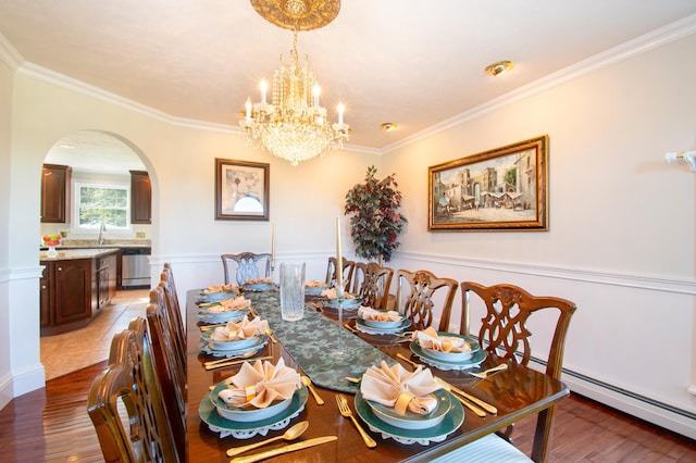 dining room featuring arched walkways, a baseboard heating unit, ornamental molding, and light wood-type flooring