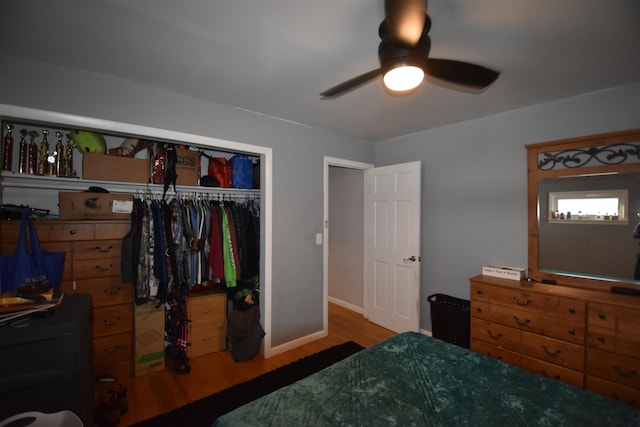 bedroom with a ceiling fan, a closet, baseboards, and wood finished floors