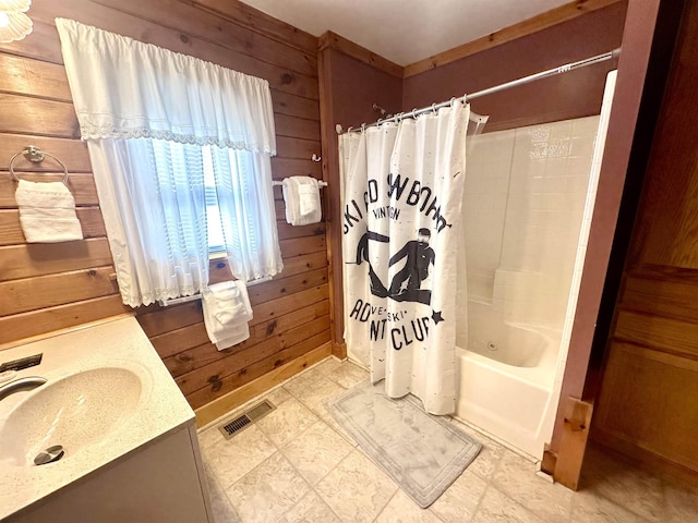 full bath featuring visible vents, shower / tub combo with curtain, wooden walls, and vanity