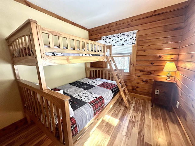 bedroom featuring wood walls and wood finished floors