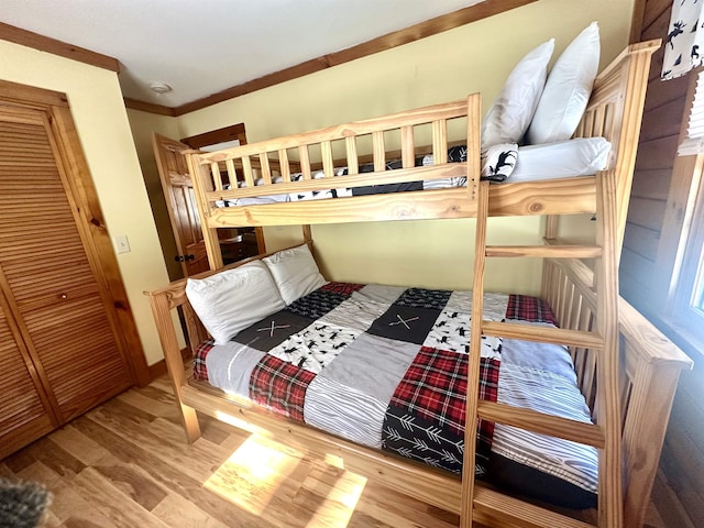 bedroom featuring crown molding, baseboards, and wood finished floors