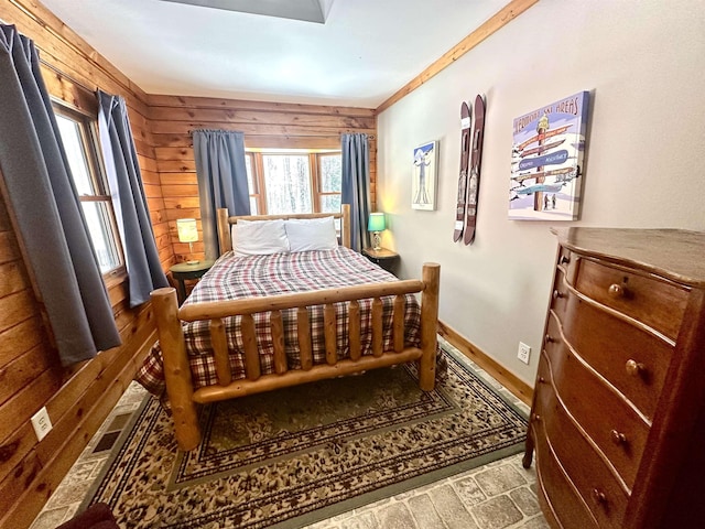 bedroom with wood walls and baseboards