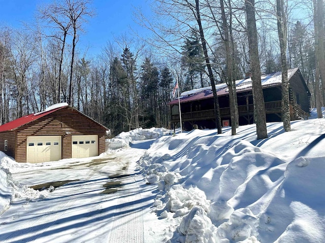 yard covered in snow with a detached garage and an outdoor structure