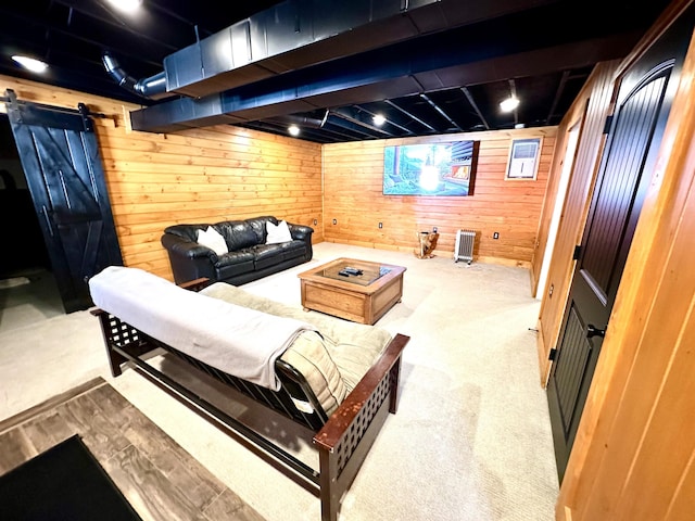 carpeted home theater room featuring wooden walls and a barn door