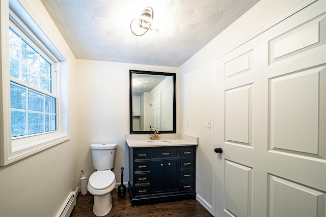 half bathroom with baseboards, a textured ceiling, toilet, and wood finished floors