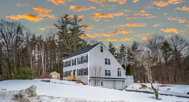 view of snow covered exterior with an attached garage