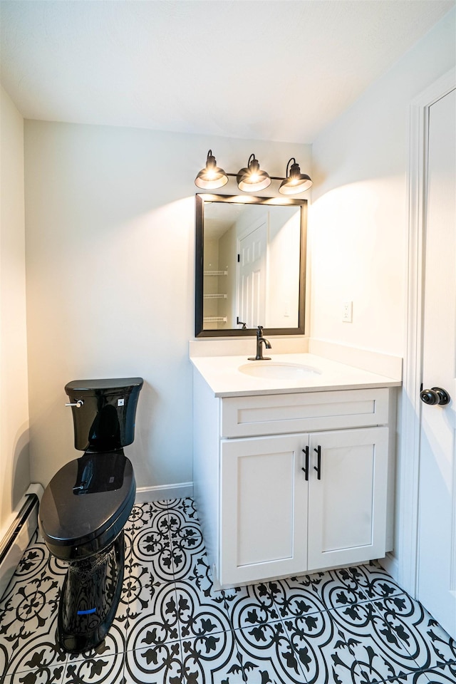 bathroom featuring a baseboard radiator, toilet, vanity, tile patterned flooring, and baseboards