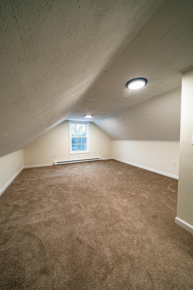 bonus room featuring a baseboard heating unit, carpet flooring, and a textured ceiling