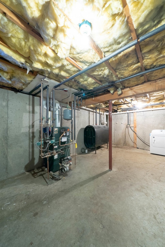 unfinished basement featuring washer / clothes dryer, a heating unit, and heating fuel