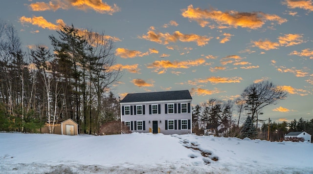 colonial inspired home featuring a storage shed and an outdoor structure