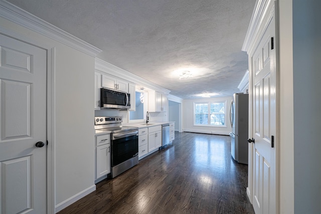 kitchen with dark wood-style floors, white cabinetry, stainless steel appliances, and crown molding